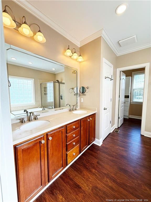 bathroom with vanity, an enclosed shower, wood-type flooring, and crown molding