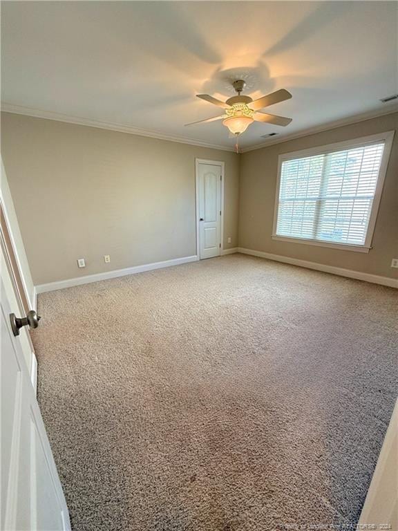 carpeted empty room with crown molding and ceiling fan