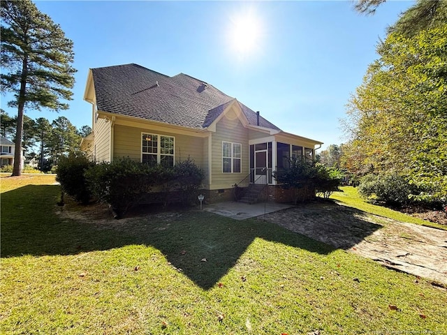 rear view of house featuring a sunroom, a yard, and a patio