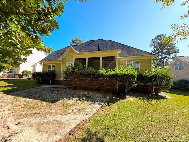 rear view of house with a lawn and a sunroom