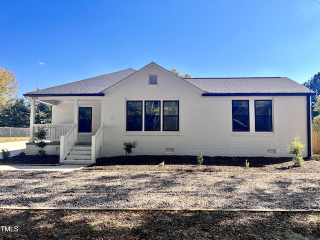 view of front of property with brick siding, roof with shingles, crawl space, and a porch