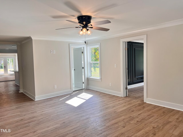 empty room with ornamental molding, a healthy amount of sunlight, and light hardwood / wood-style flooring