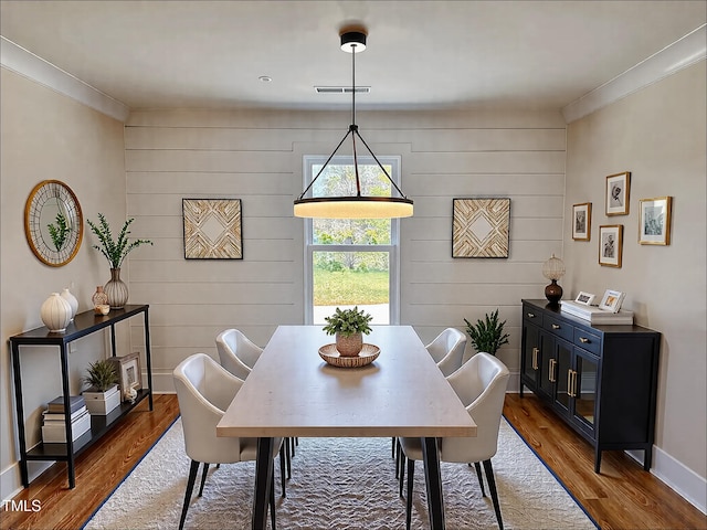 dining area featuring hardwood / wood-style flooring and ornamental molding