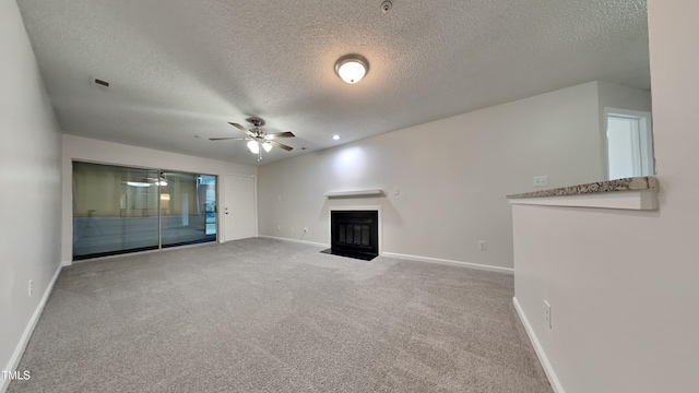 unfurnished living room featuring a textured ceiling, carpet floors, and ceiling fan