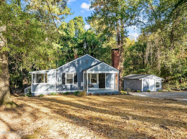 view of front of home with covered porch and a storage unit