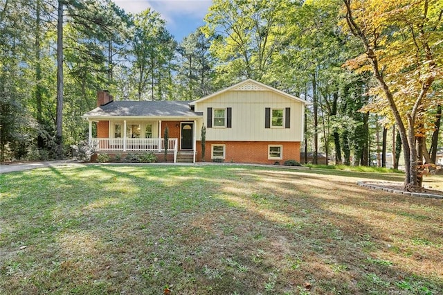 tri-level home with a porch and a front lawn