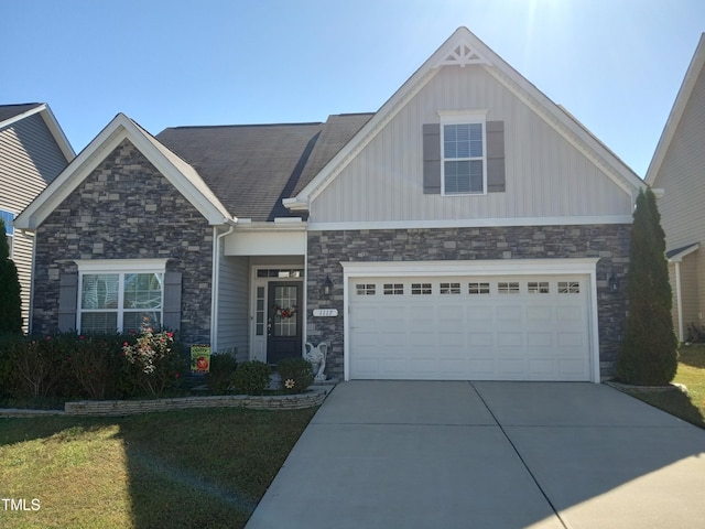 craftsman-style home featuring a front yard and a garage