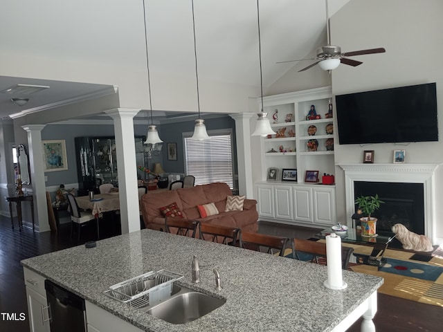 kitchen with dark hardwood / wood-style floors, sink, vaulted ceiling, white cabinetry, and light stone counters