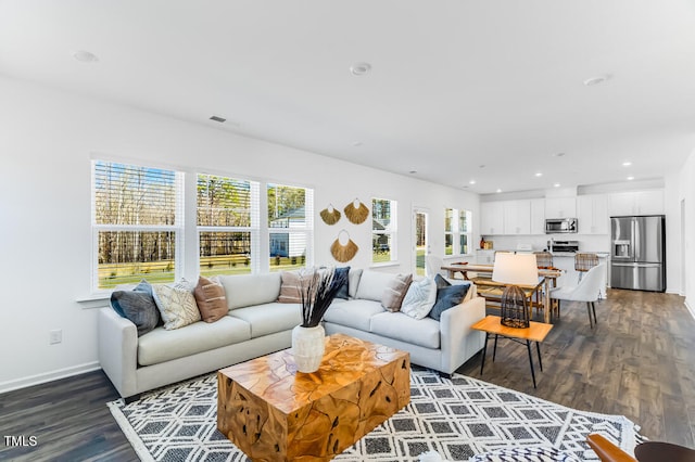 living area featuring visible vents, baseboards, recessed lighting, and dark wood-style flooring