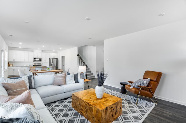 living area featuring recessed lighting, dark wood finished floors, baseboards, and stairs