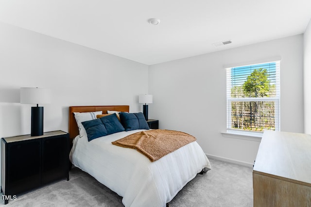 bedroom featuring light carpet, visible vents, and baseboards