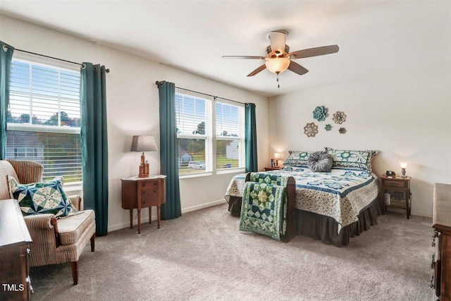 carpeted bedroom featuring ceiling fan and multiple windows