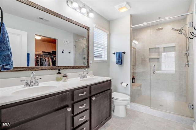 bathroom featuring tile patterned floors, vanity, an enclosed shower, and toilet