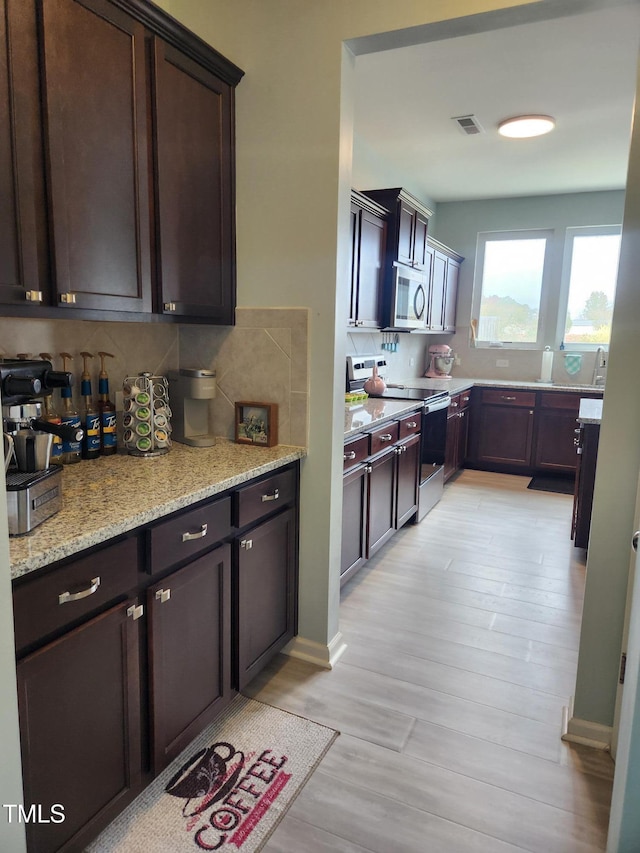 kitchen featuring dark brown cabinets, stainless steel appliances, and light hardwood / wood-style floors