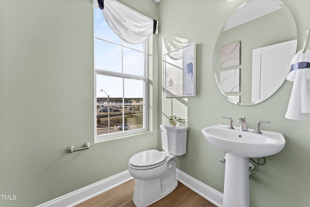 bathroom with hardwood / wood-style floors, toilet, and sink