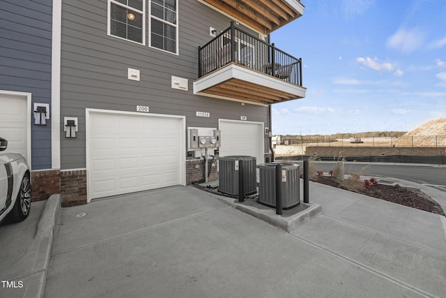 exterior space featuring a balcony, a garage, and central AC unit