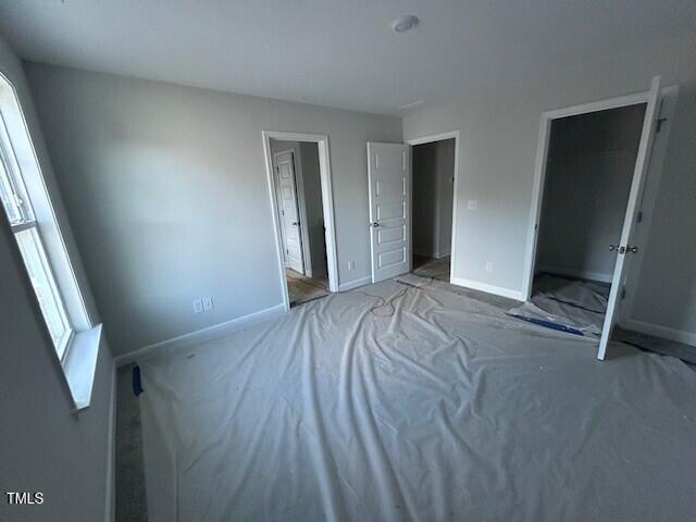 unfurnished bedroom featuring a closet and multiple windows