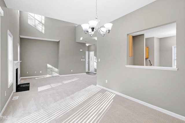 interior space with carpet floors, sink, and a notable chandelier