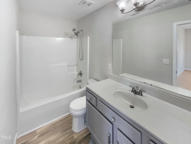 full bathroom with toilet, hardwood / wood-style flooring, vanity, and washtub / shower combination