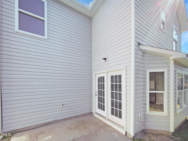 view of exterior entry with a patio area