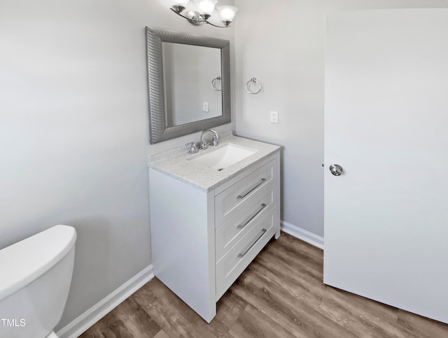 bathroom with toilet, hardwood / wood-style flooring, and vanity