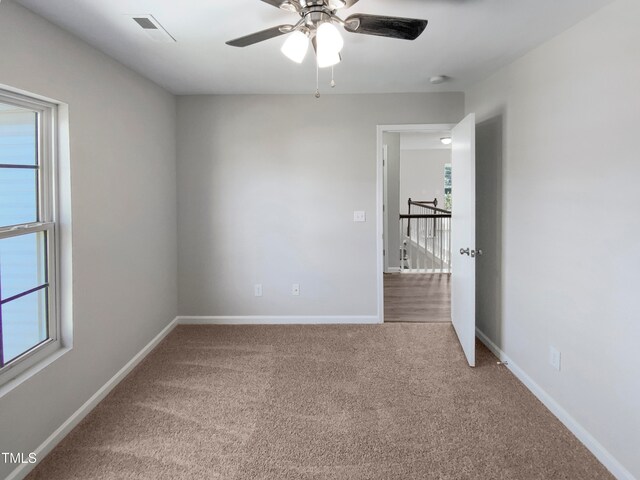 empty room featuring carpet flooring and ceiling fan