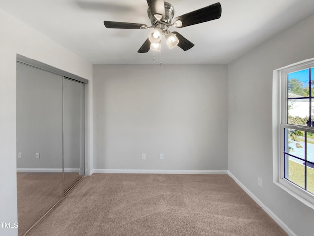 unfurnished bedroom featuring a closet, ceiling fan, and carpet