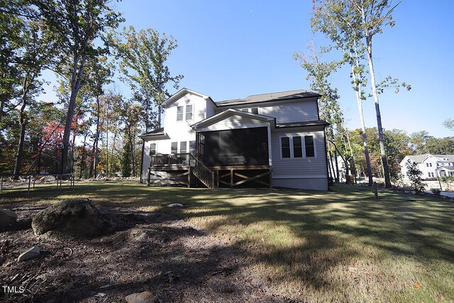 rear view of property featuring a sunroom and a lawn