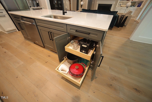 kitchen with white cabinetry, light wood-type flooring, dishwasher, gray cabinetry, and sink