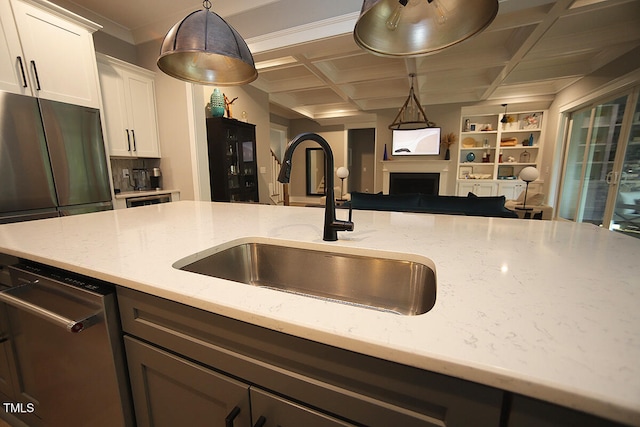 kitchen with light stone countertops, sink, pendant lighting, and white cabinets