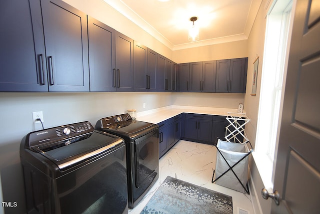 laundry room featuring crown molding, washing machine and dryer, and cabinets