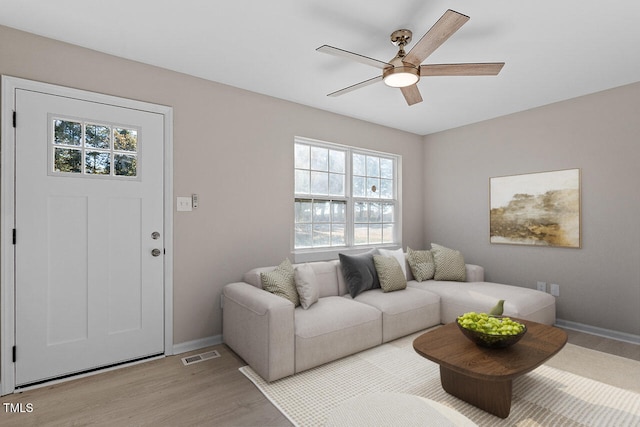 living room featuring light hardwood / wood-style flooring and ceiling fan