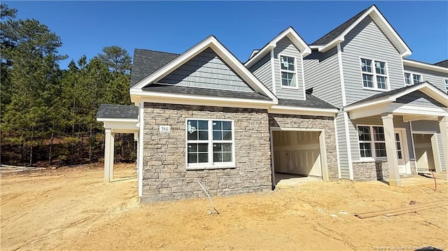 view of front of property featuring a garage and stone siding