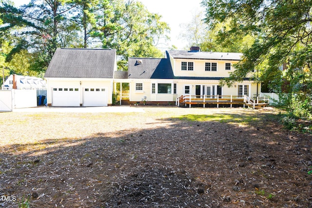 back of house featuring a wooden deck and a garage