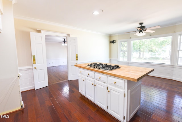 kitchen with white cabinetry, dark wood-type flooring, stainless steel gas cooktop, a center island, and butcher block countertops