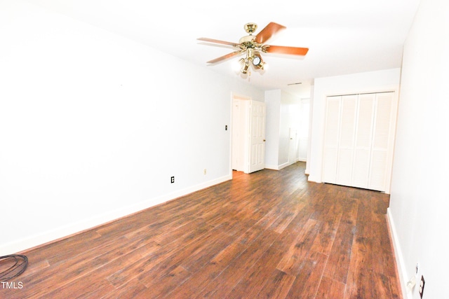 unfurnished bedroom with dark wood-type flooring, ceiling fan, and a closet