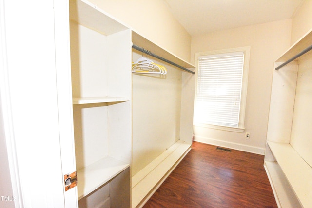 spacious closet with dark hardwood / wood-style flooring