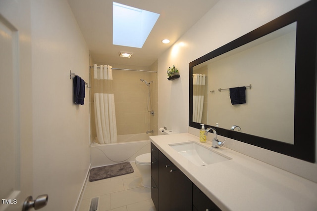 full bathroom featuring shower / bathtub combination with curtain, toilet, a skylight, vanity, and tile patterned flooring