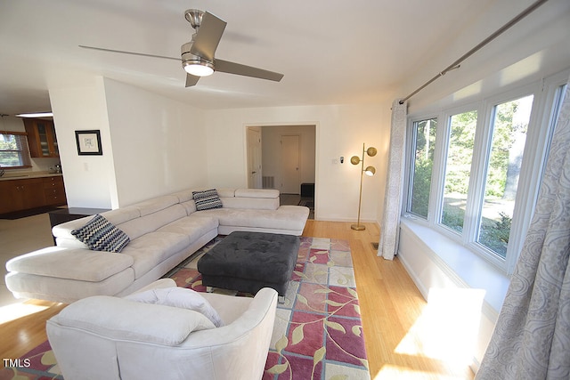 living room featuring light hardwood / wood-style floors and ceiling fan