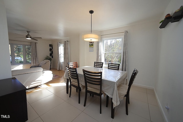 tiled dining area featuring a healthy amount of sunlight and ceiling fan