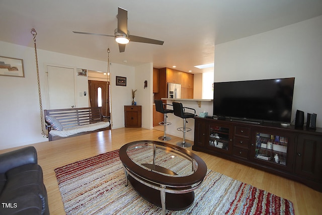 living room featuring light wood-type flooring and ceiling fan