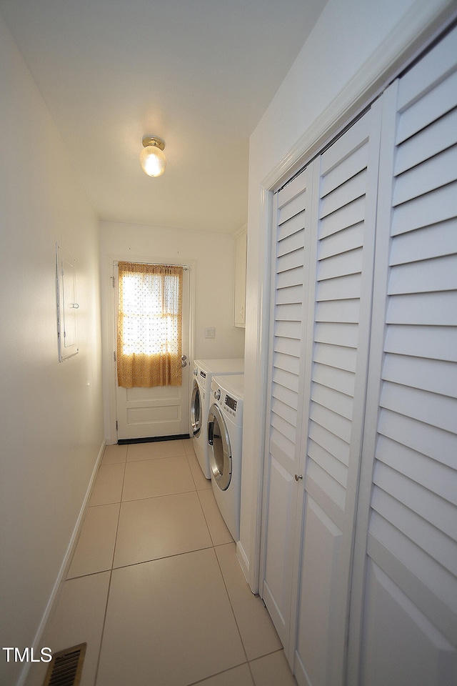 clothes washing area featuring light tile patterned flooring and independent washer and dryer