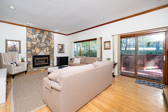 living room featuring ornamental molding, a textured ceiling, and light hardwood / wood-style floors