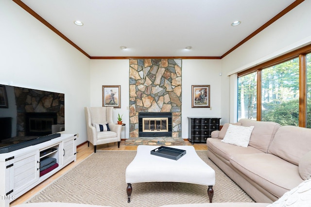 living room with a stone fireplace, light hardwood / wood-style flooring, and ornamental molding