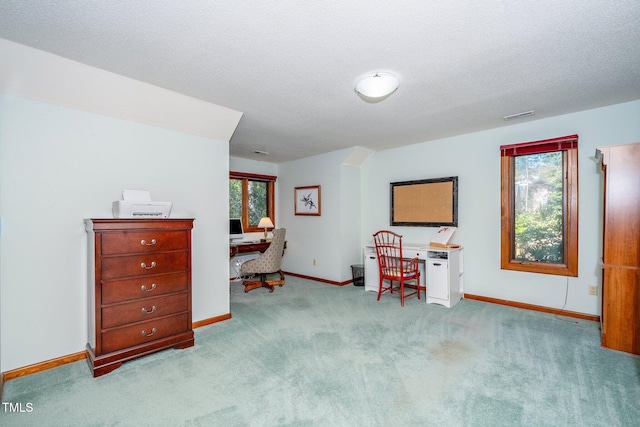 misc room with light carpet, a wealth of natural light, a textured ceiling, and built in desk