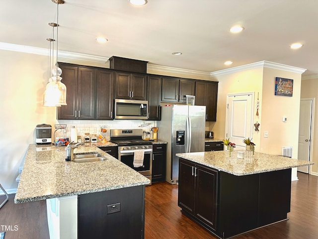 kitchen featuring light stone countertops, dark wood-type flooring, sink, pendant lighting, and stainless steel appliances