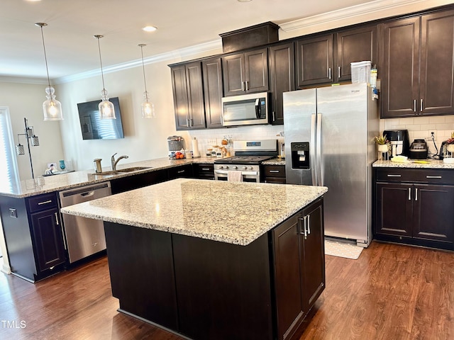 kitchen with appliances with stainless steel finishes, kitchen peninsula, a kitchen island, and pendant lighting