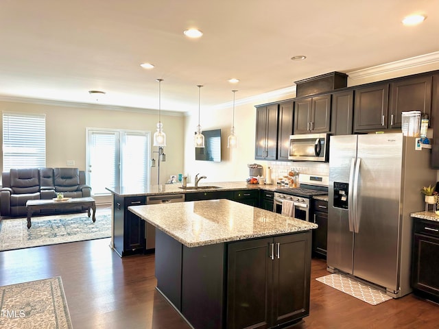 kitchen with dark hardwood / wood-style floors, kitchen peninsula, stainless steel appliances, sink, and decorative light fixtures