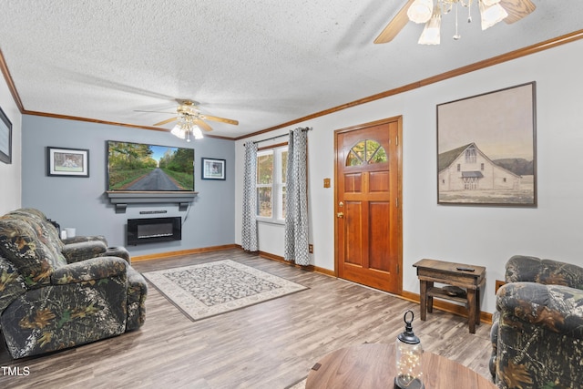 living room featuring ornamental molding, a textured ceiling, wood-type flooring, and ceiling fan