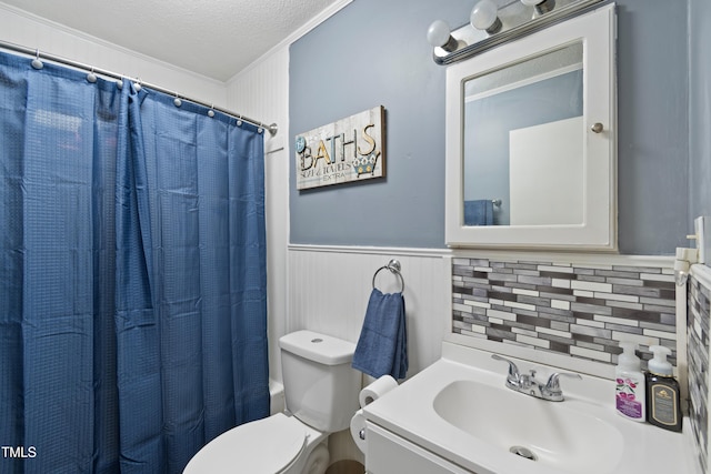 bathroom with toilet, crown molding, a shower with shower curtain, vanity, and a textured ceiling